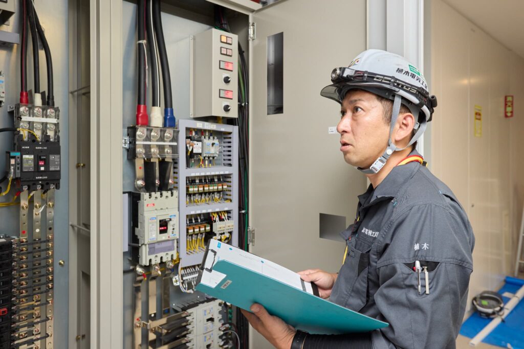制御盤の点検をしている植木電機工業株式会社 代表取締役 植木紀雄の写真