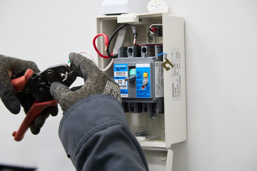 配線作業でペンチを使い電線を加工している様子